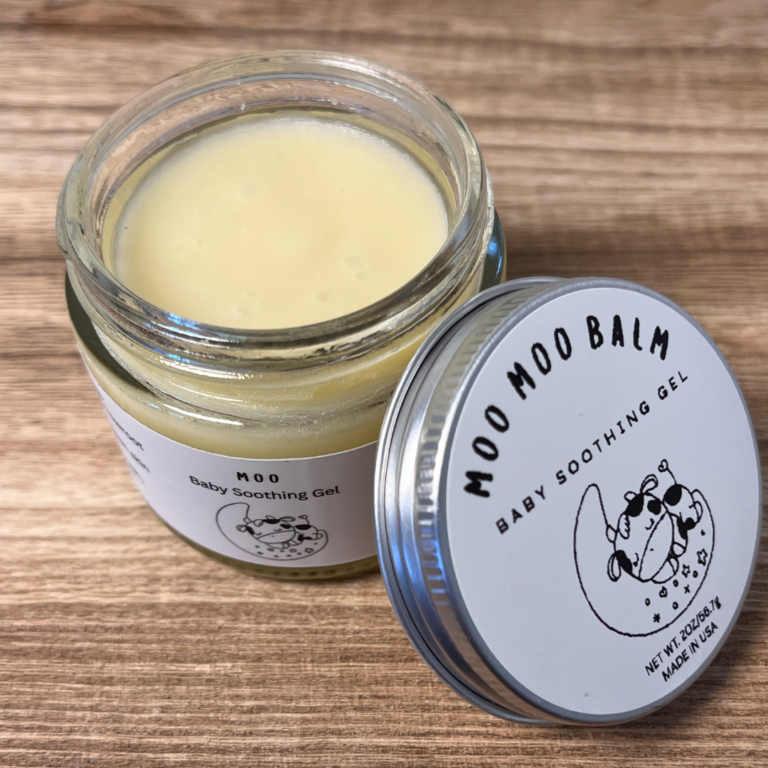 Close-up of Moo Moo Balm Baby Soothing Gel jar on wood background — a gentle, natural balm that calms and protects delicate baby skin.