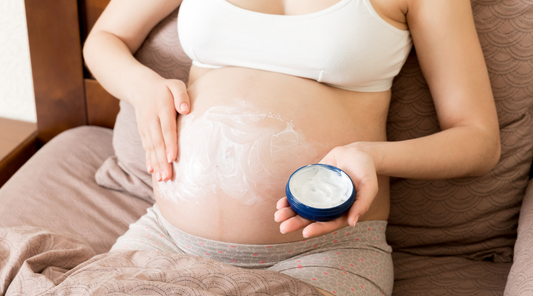 Pregnant woman applying moisturizing cream on her belly to soothe dry, sensitive skin during pregnancy.