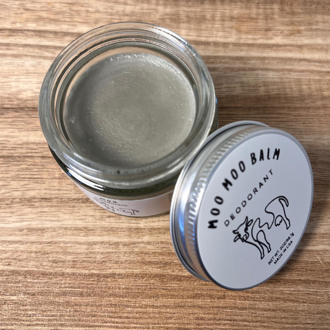 Moo Moo Balm magnesium deodorant in a glass jar with lid on wooden surface — tallow-based, aluminum-free, fragrance-free deodorant formulated for sensitive skin.