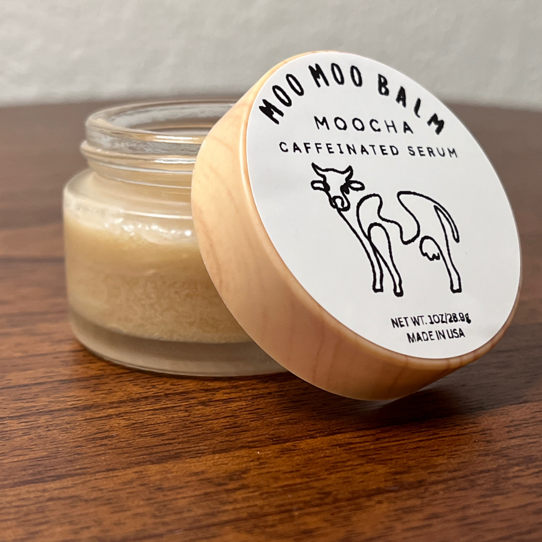 Moo Moo Balm Moocha Caffeinated Serum in glass jar with wooden lid on a natural wooden surface — tallow-based caffeine eye and face cream made in USA.